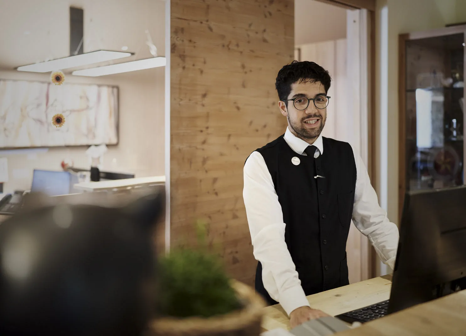 man at a reception desk with a computer in a modern office