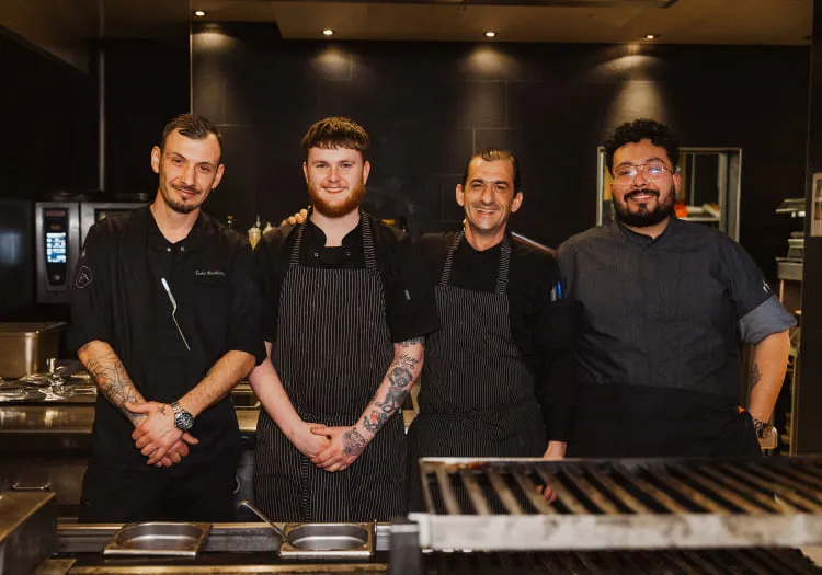 Vier Köche stehen in einer modernen Küche