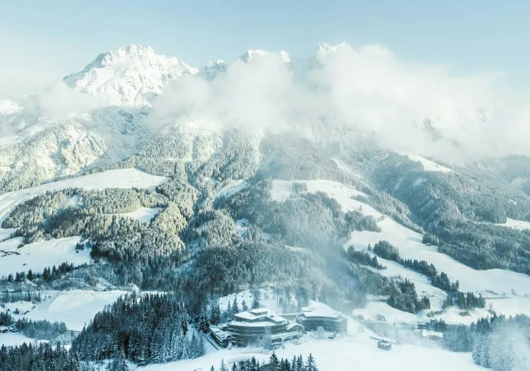 Schneebedeckte Berge und Tal mit Wolken