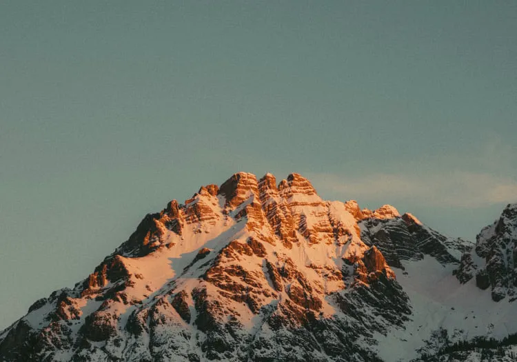 Berglandschaft mit schneebedeckten Gipfeln und warmem Licht