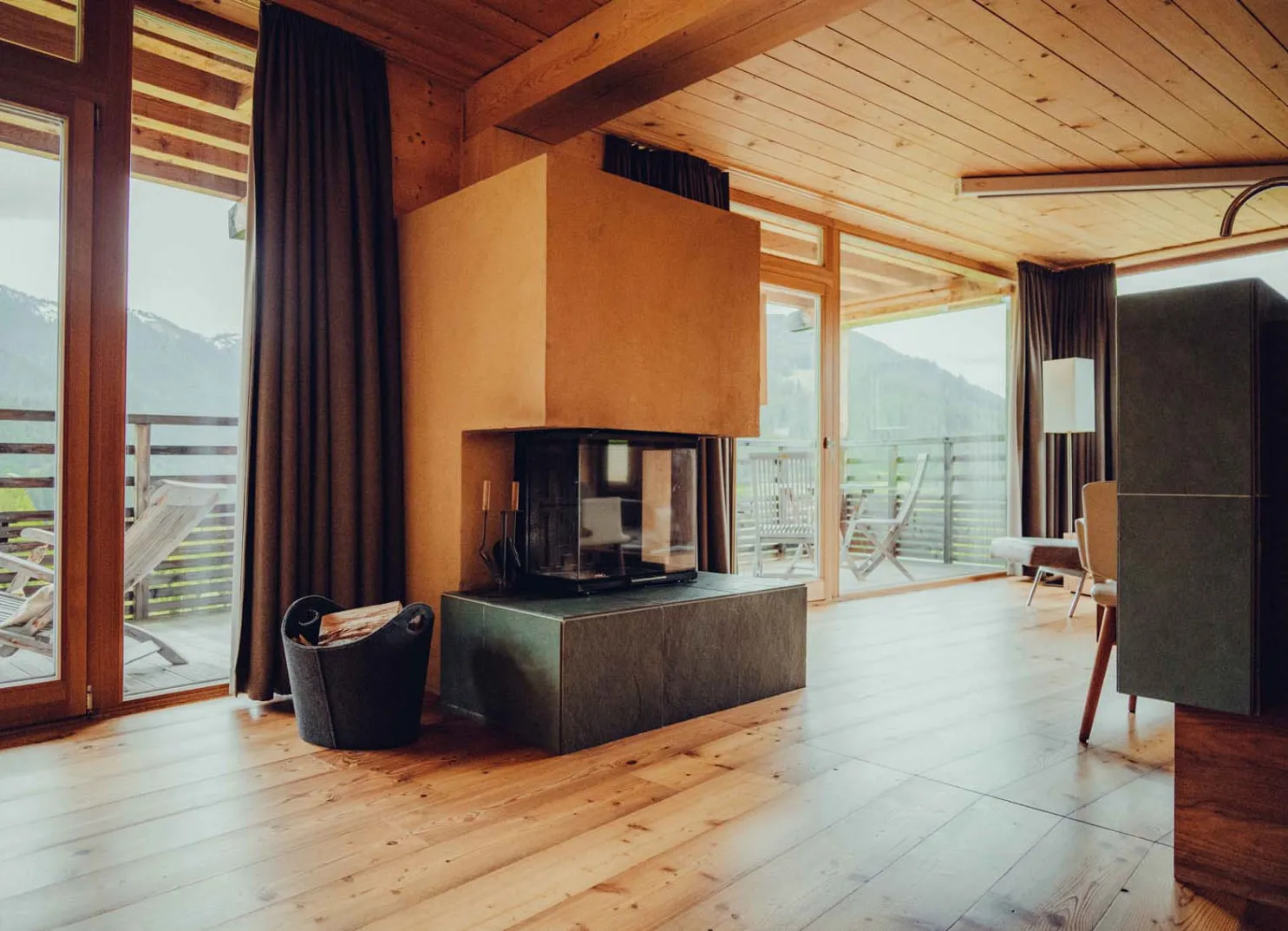 Modernes Zimmer im Holzhotel Forsthofalm mit Holzfußboden und Kamin