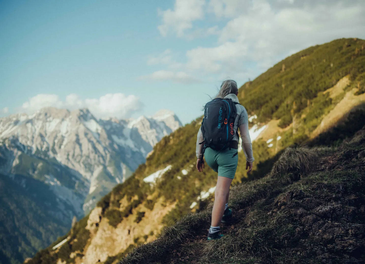 Wanderer am Holzhotel Forsthofalm in Leogang mit Bergpanorama