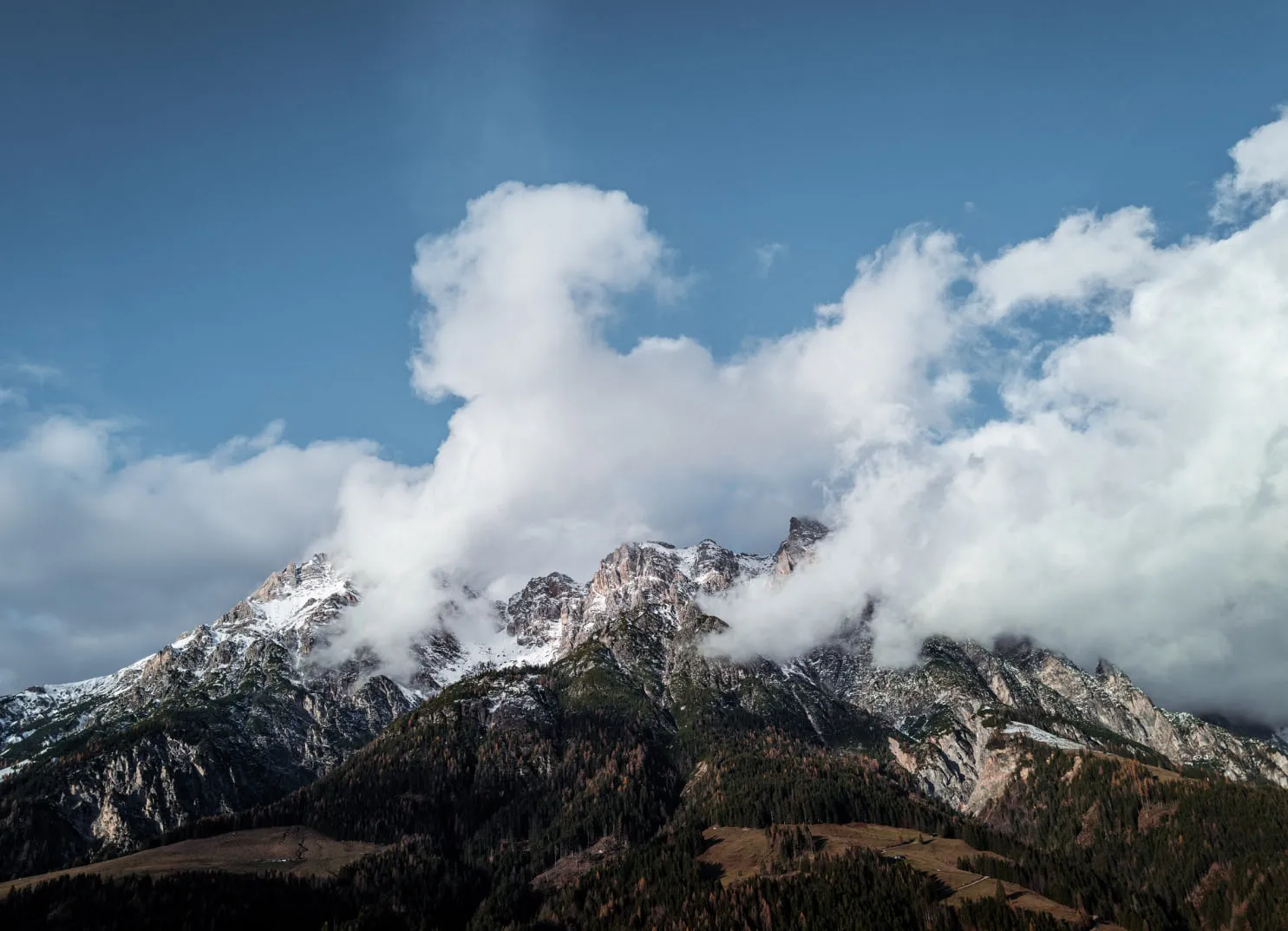 Mountain landscape with clouds and snowy peaks