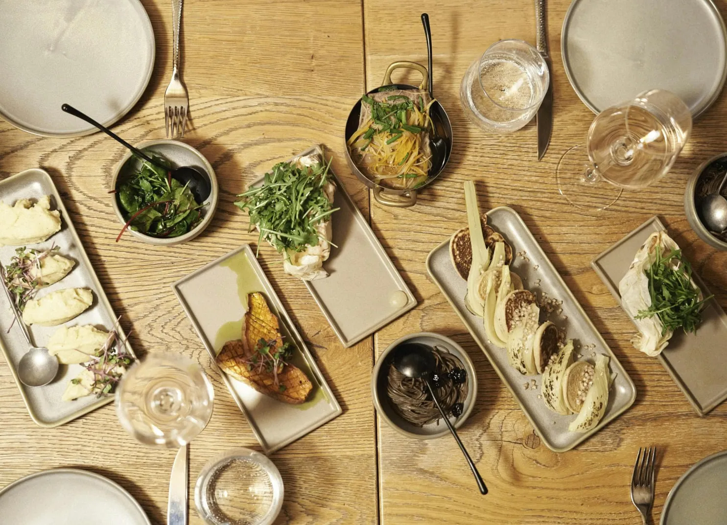 a wooden table set with various dishes and drinks