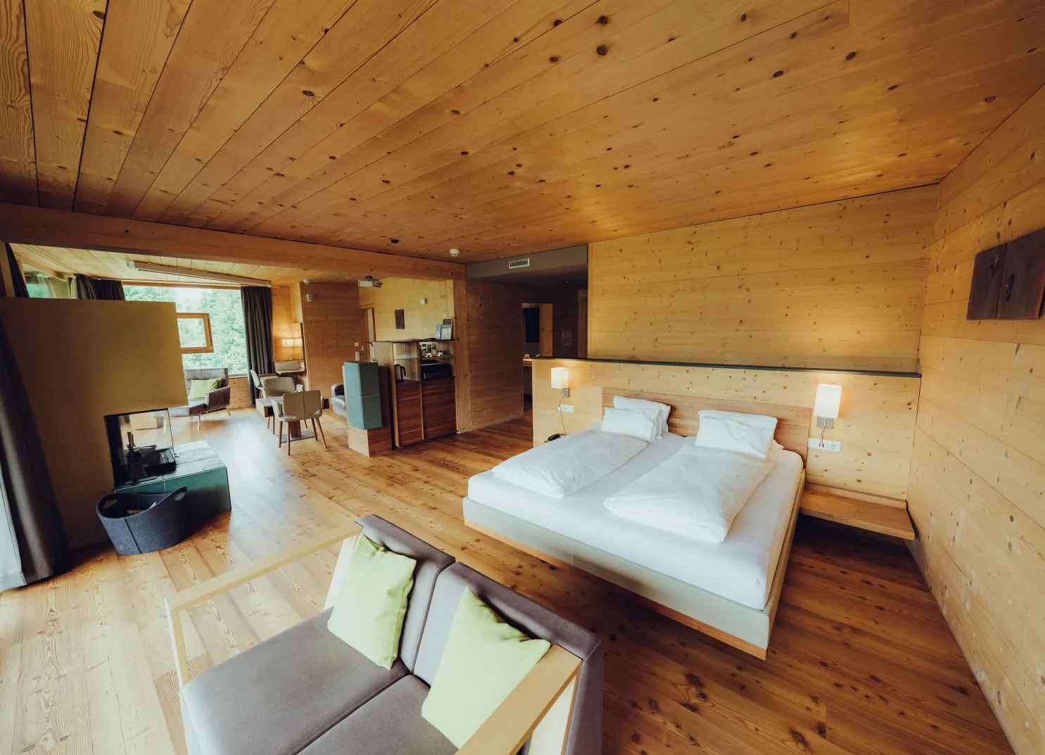 modern hotel room with wooden walls, a large bed, and a seating area
