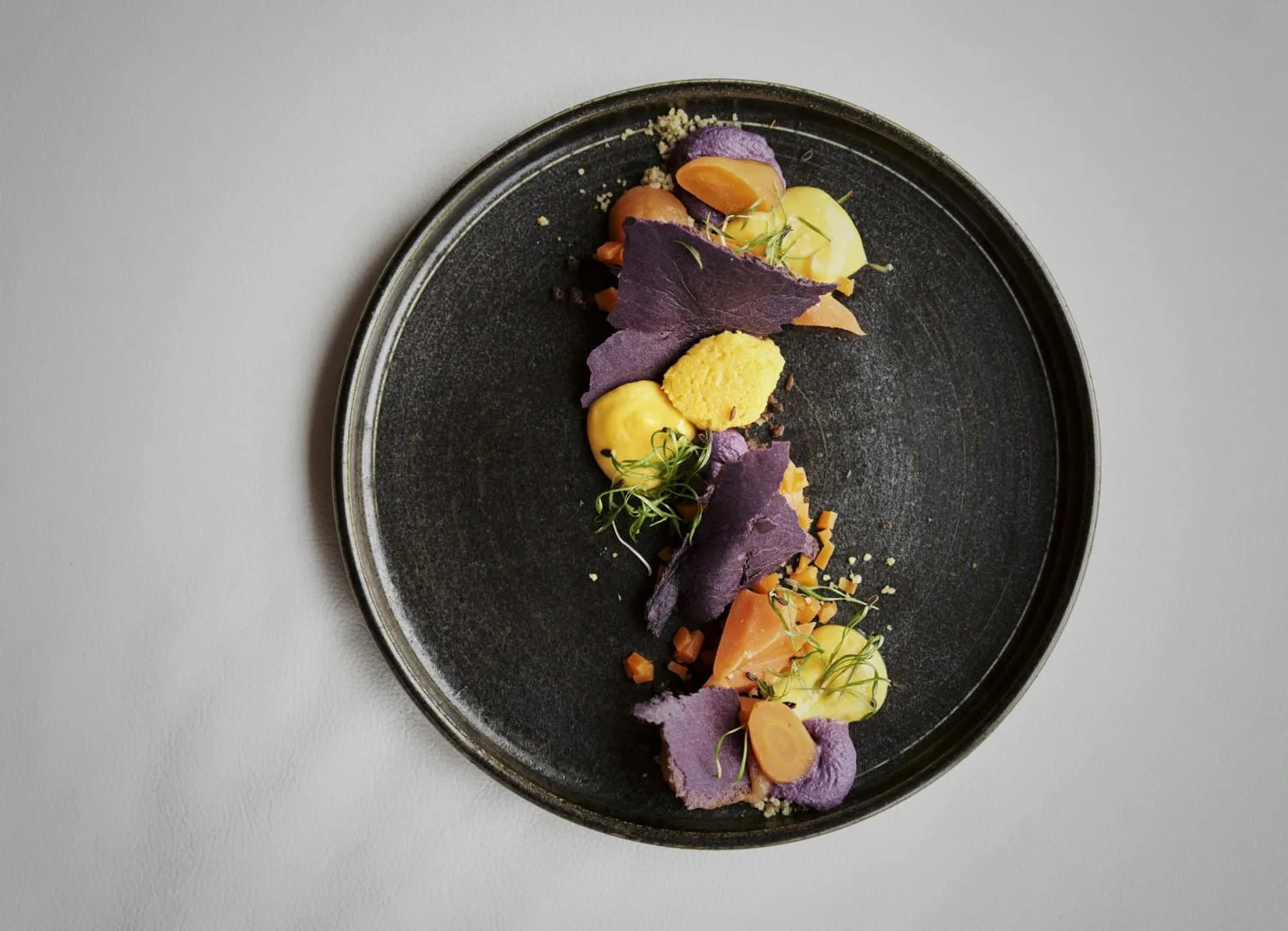 Plate with colorful food presentation featuring purple and yellow elements