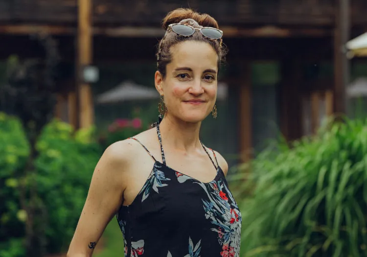 Woman in floral dress standing in a garden with greenery