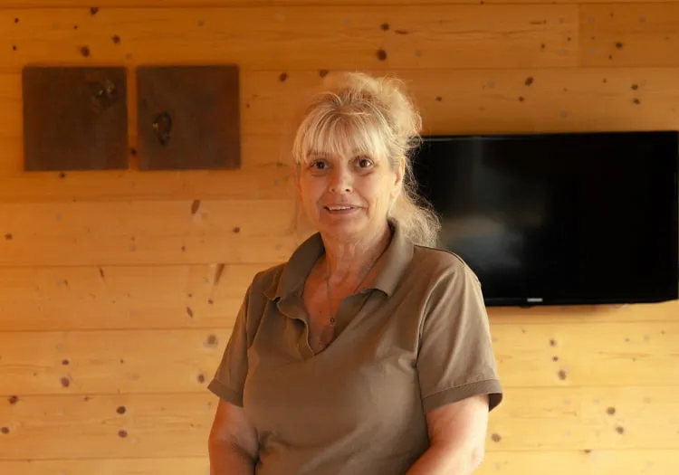 Woman in a wooden room with TV and wall art