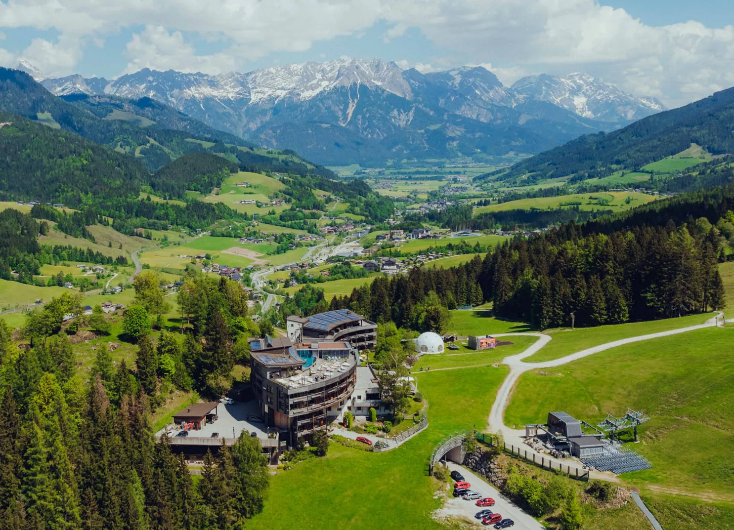Landschaft mit Hotel Klein und den Alpen im Hintergrund
