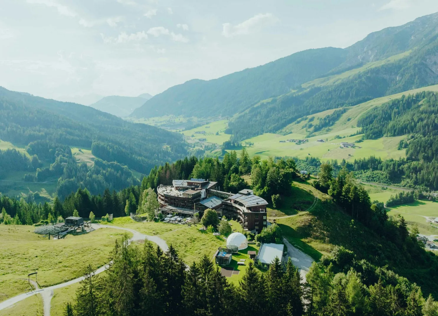 Landschaft mit Hügeln, Wäldern und modernen Gebäuden in den Bergen