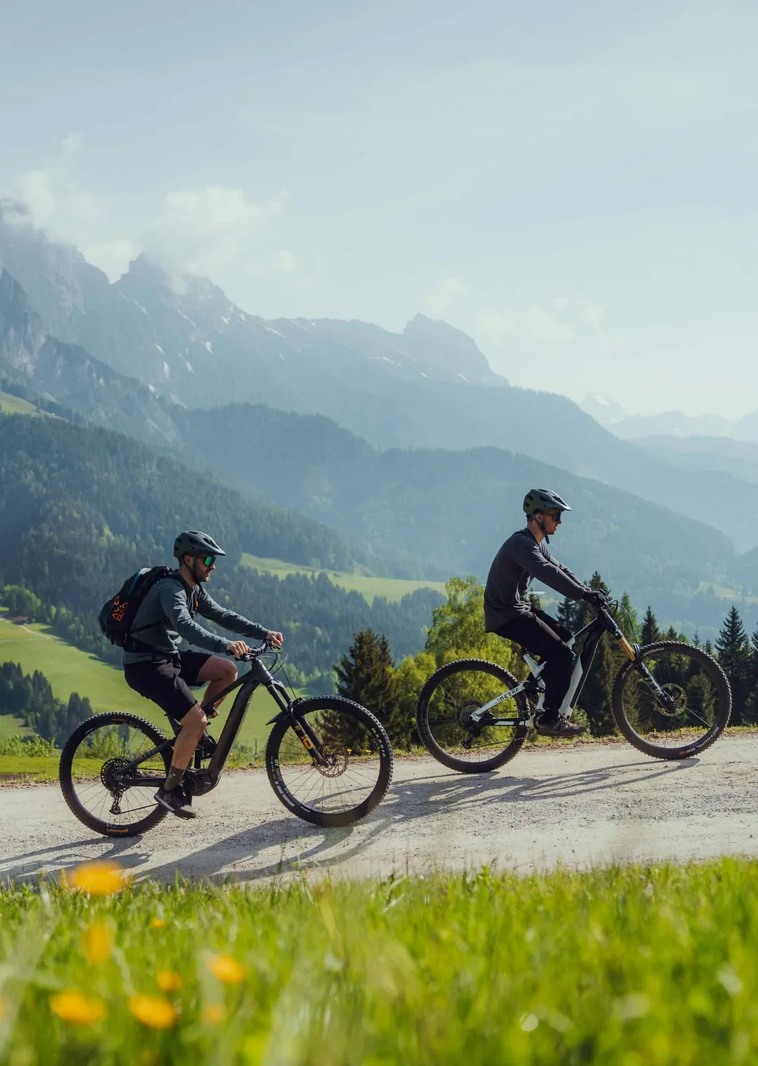 Zwei Radfahrer auf einem Weg in einer bergigen Landschaft