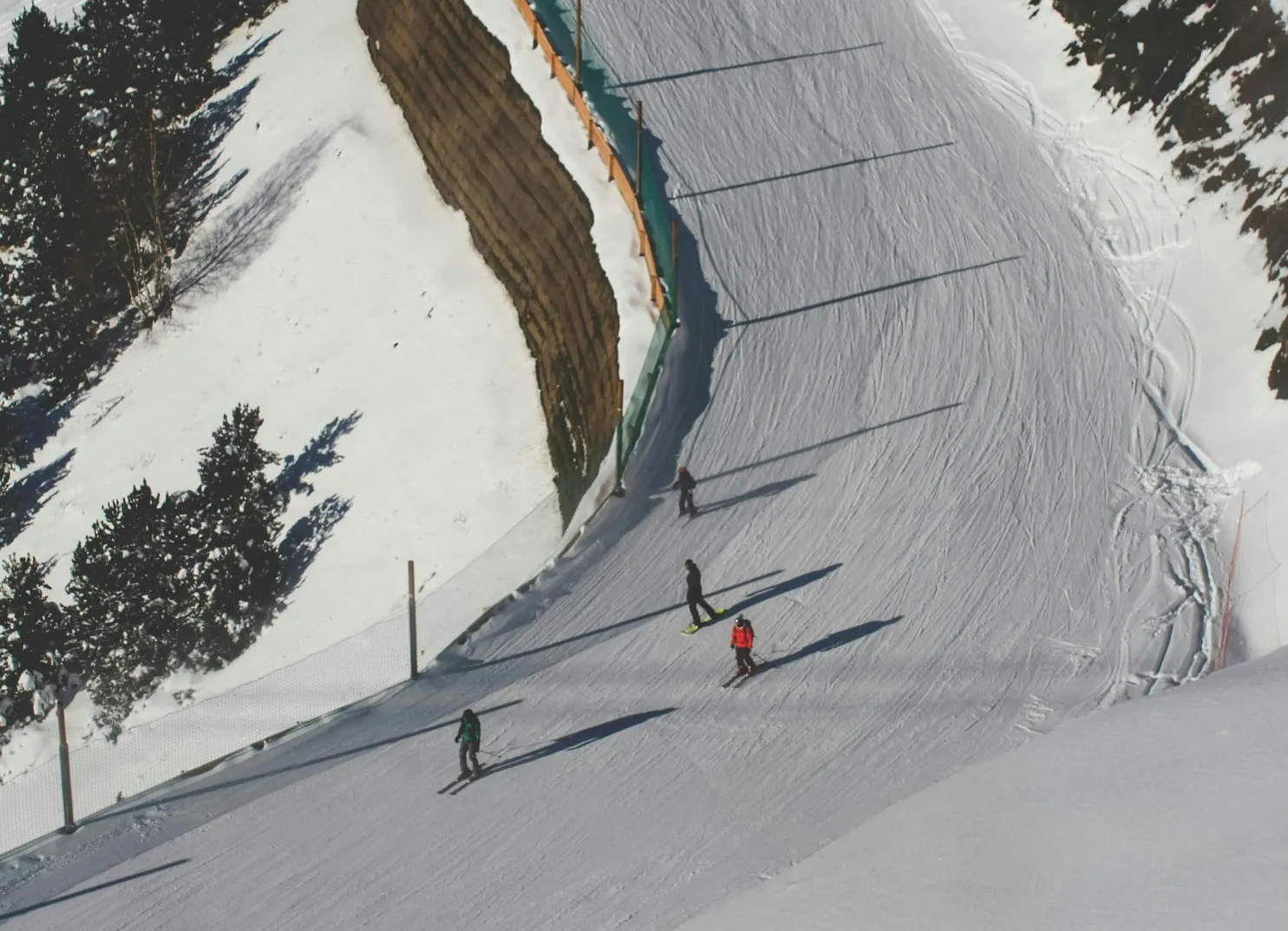 Skifahrer auf einer schneebedeckten Piste mit Bäumen im Hintergrund