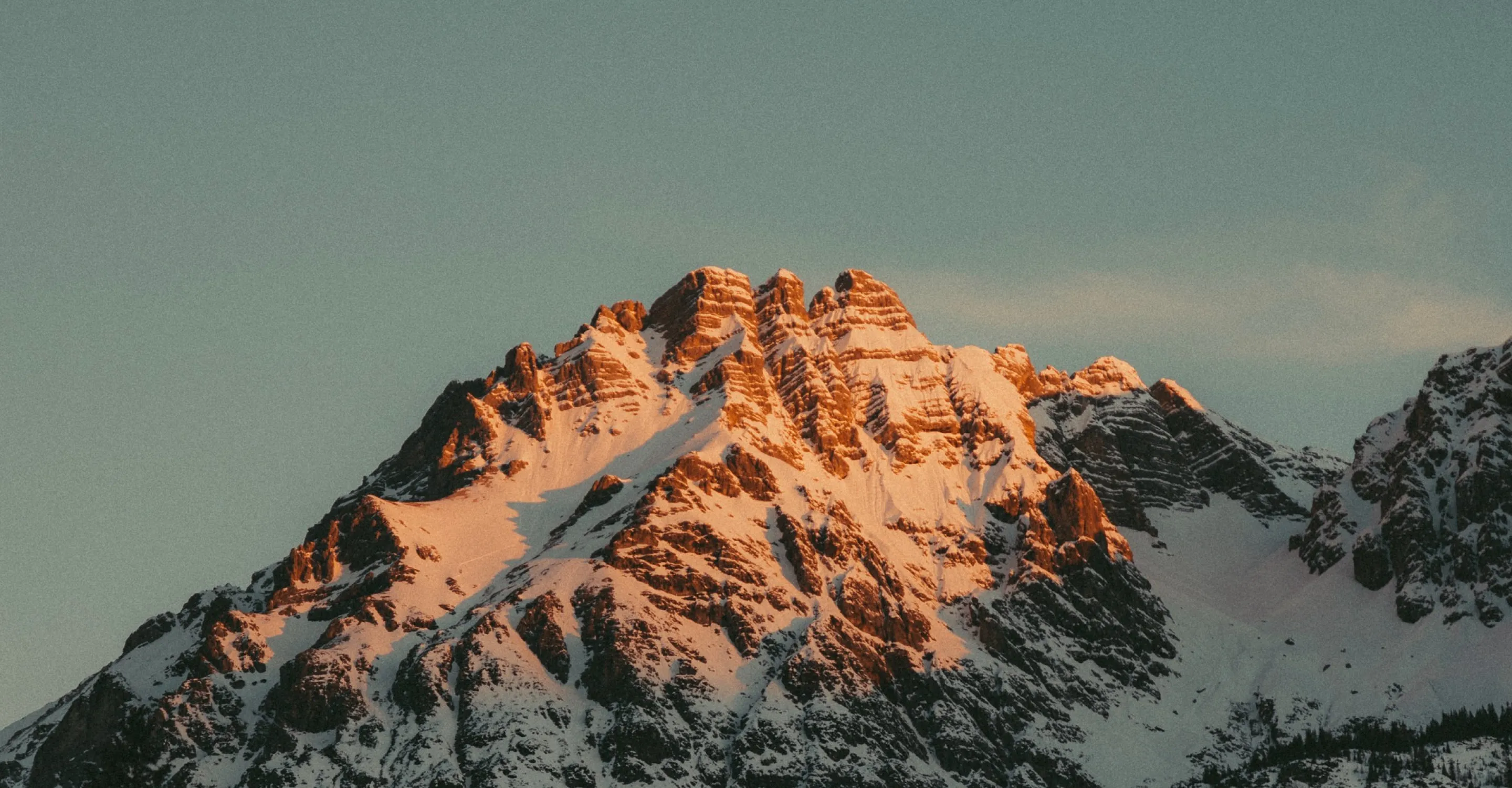 Mountain landscape with snow-capped peaks in sunlight