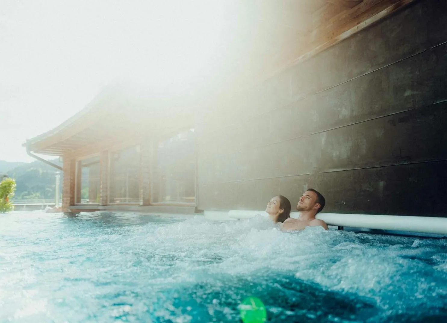 couple enjoying a swim in a pool with sunlight