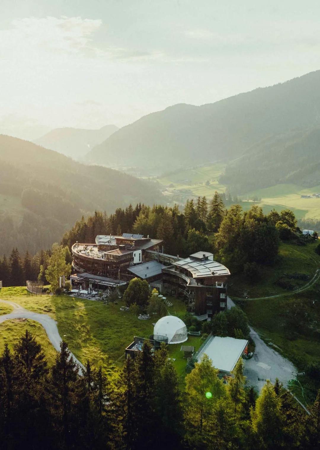Holzhotel Forsthofalm mit Bergen im Hintergrund
