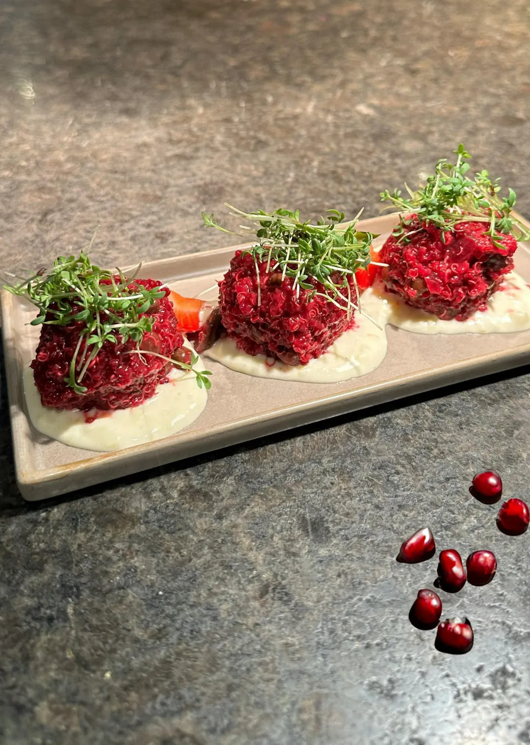 Drei Gerichte mit Rübenbelag und Microgreens auf einem beigen Teller