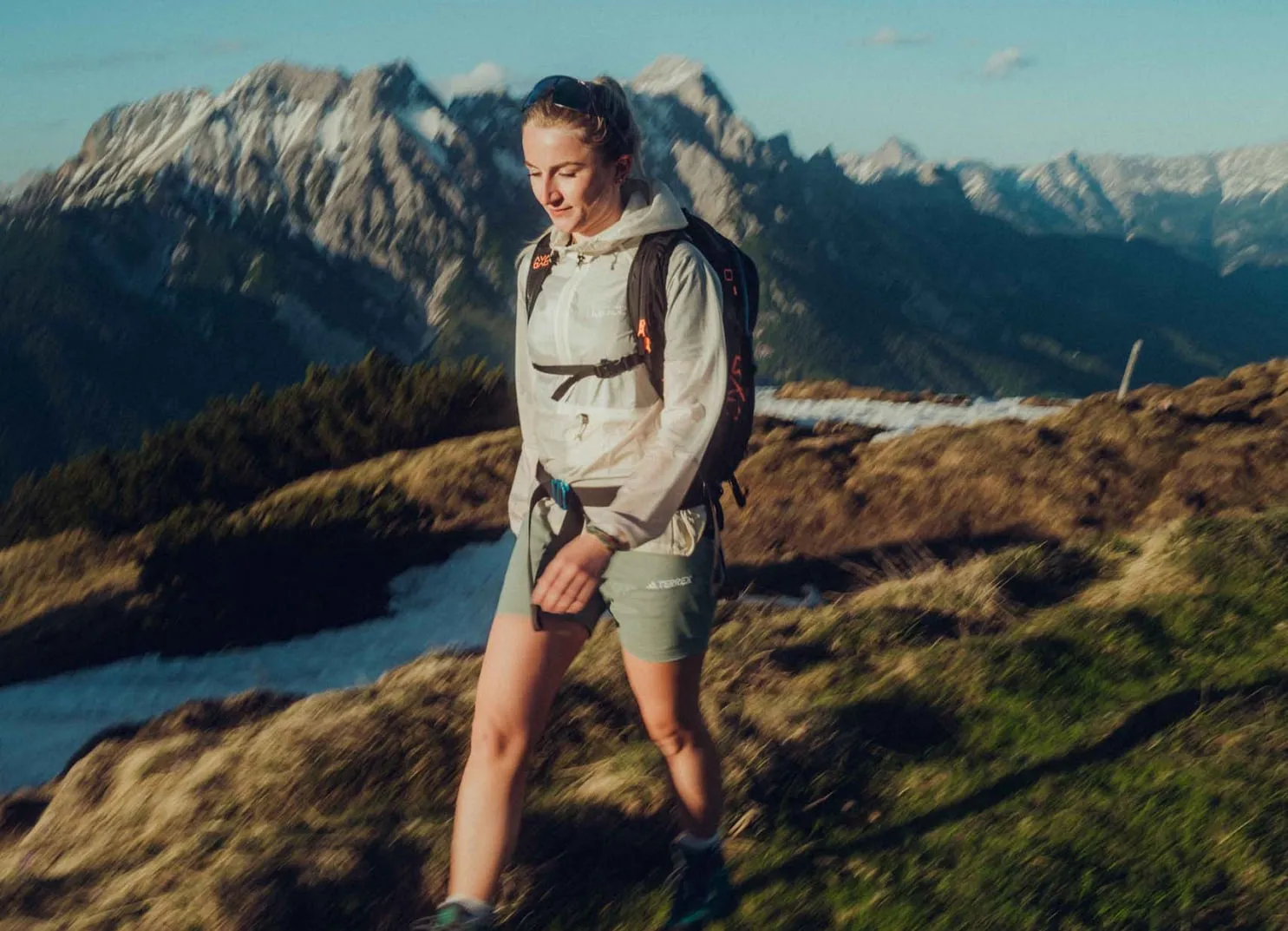 Junge Frau wandert in den Bergen mit einem Rucksack