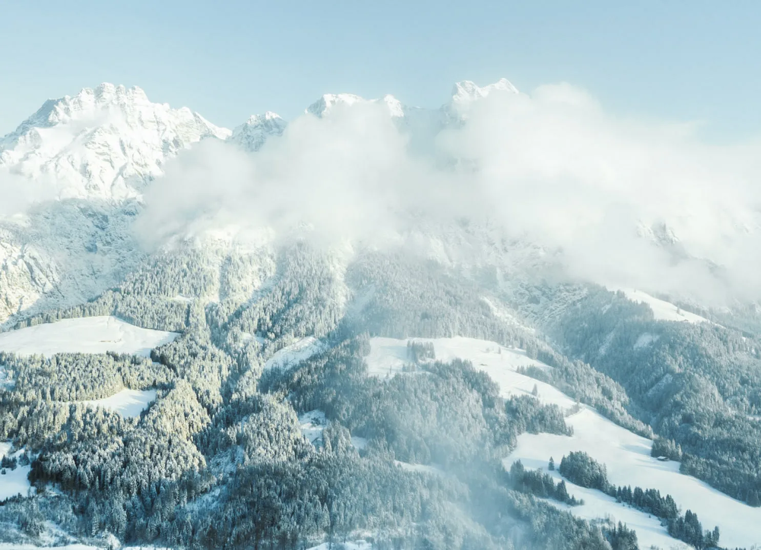 Blick auf verschneite Berge und Wälder bei Leogang.