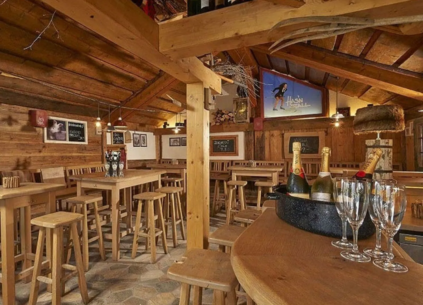 Innenansicht einer rustikalen Bar mit Holzmöbeln und Champagner