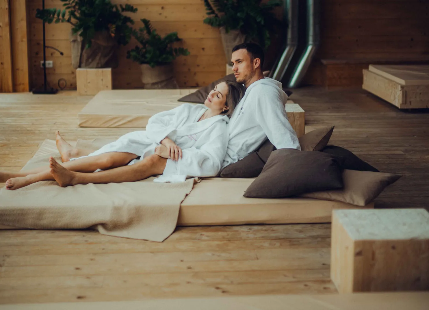 Couple in bathrobes relaxing in a wooden hotel at Forsthofalm, Leogang