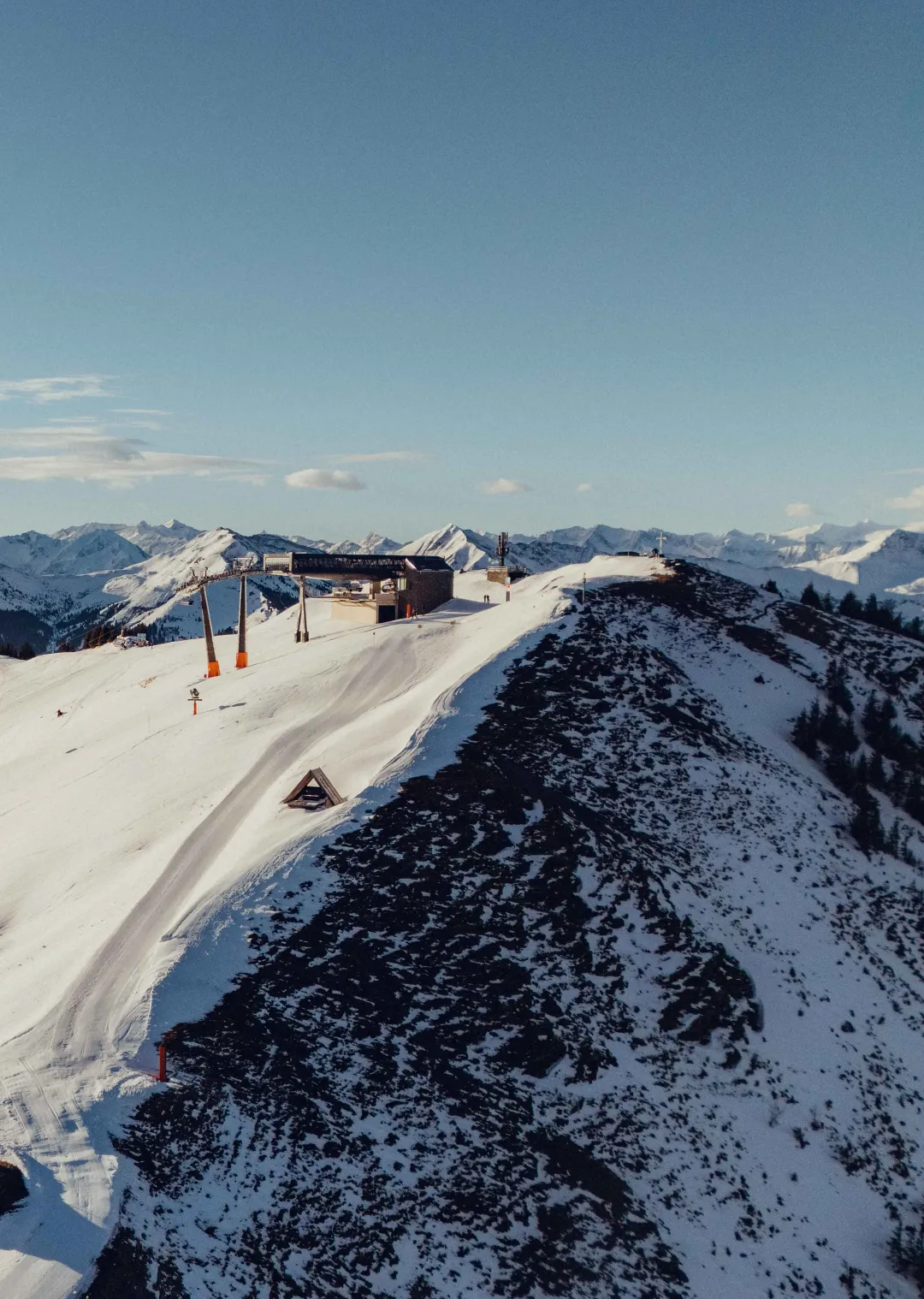 Berglandschaft mit Schneepisten und Holzhotel Forsthofalm in Leogang