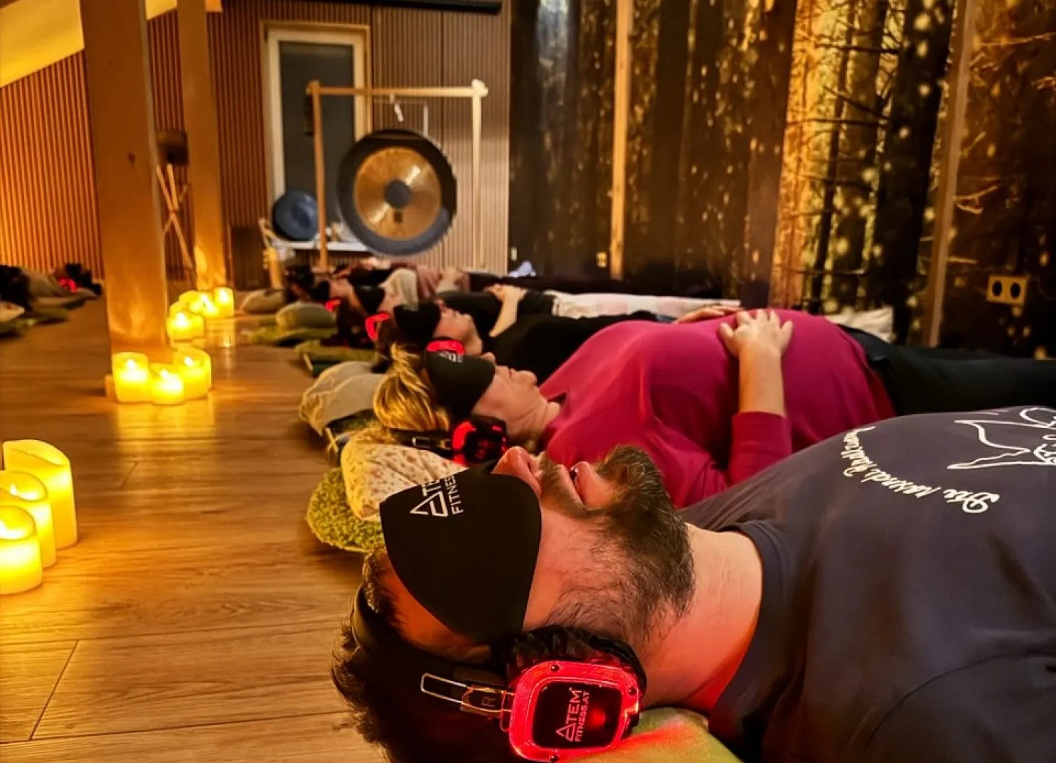 Menschen liegen entspannt auf dem Boden mit Kopfhörern und Augenbinden.