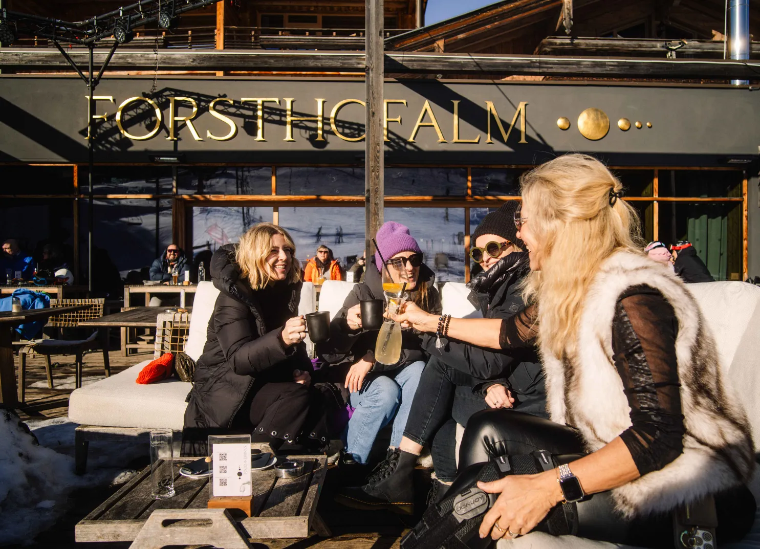 Gruppe von vier Frauen bei Froschtihalm, die auf einer Terrasse feiern