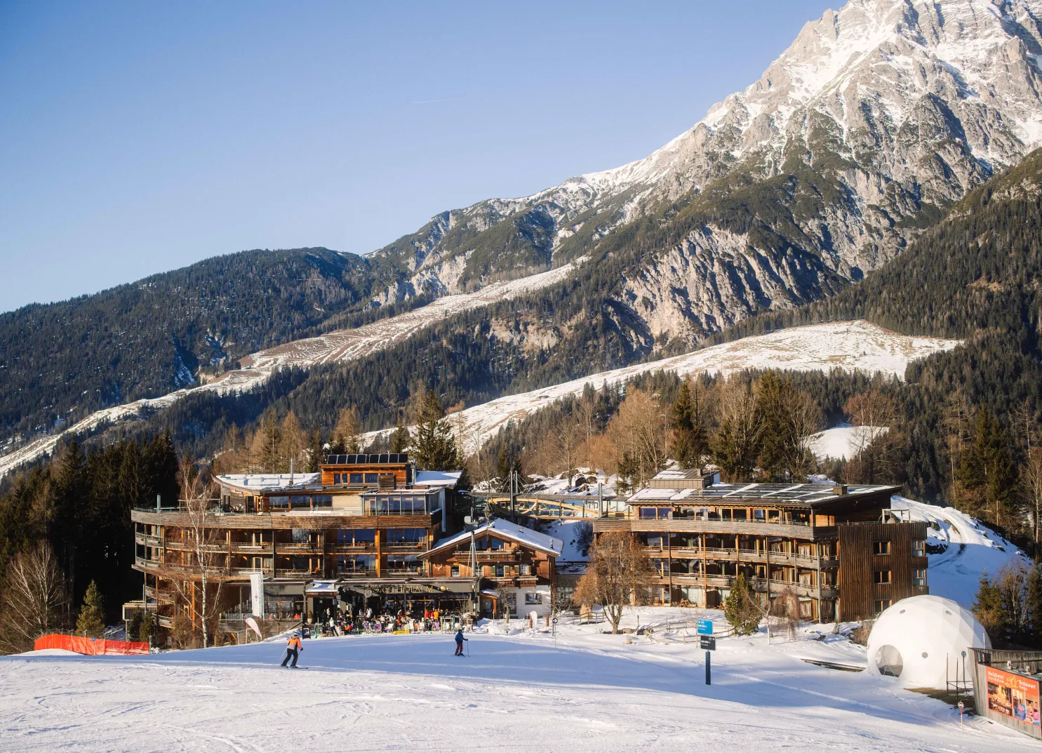 Alpine hotel with snowy landscape and ski slope