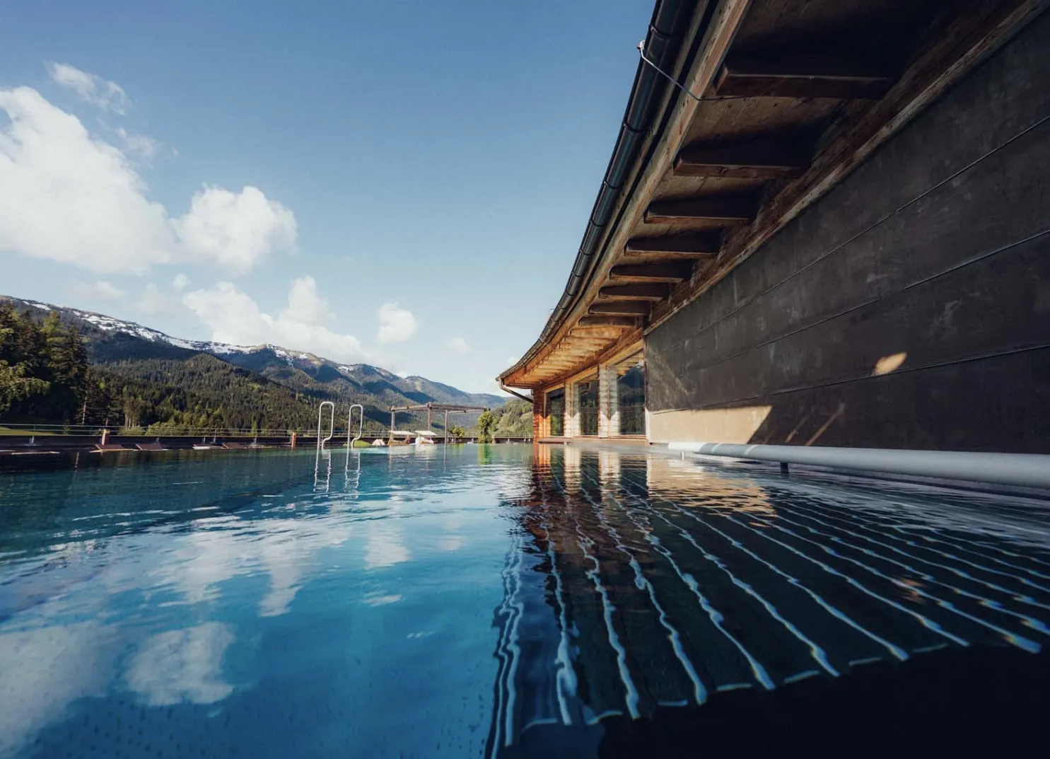 Infinity pool with mountain view and clouds in the sky