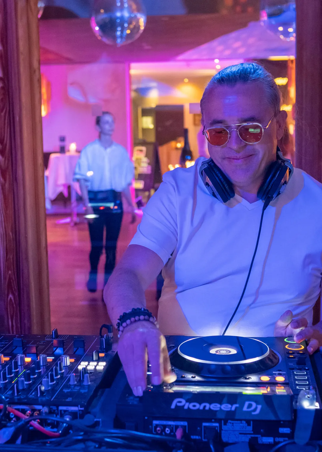 DJ playing music with colorful lighting in the background