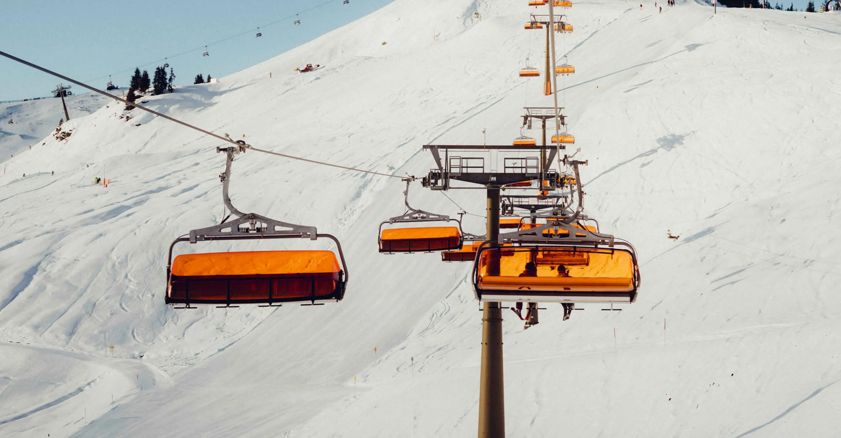 Orange Gondeln auf einem Skilift im Schnee