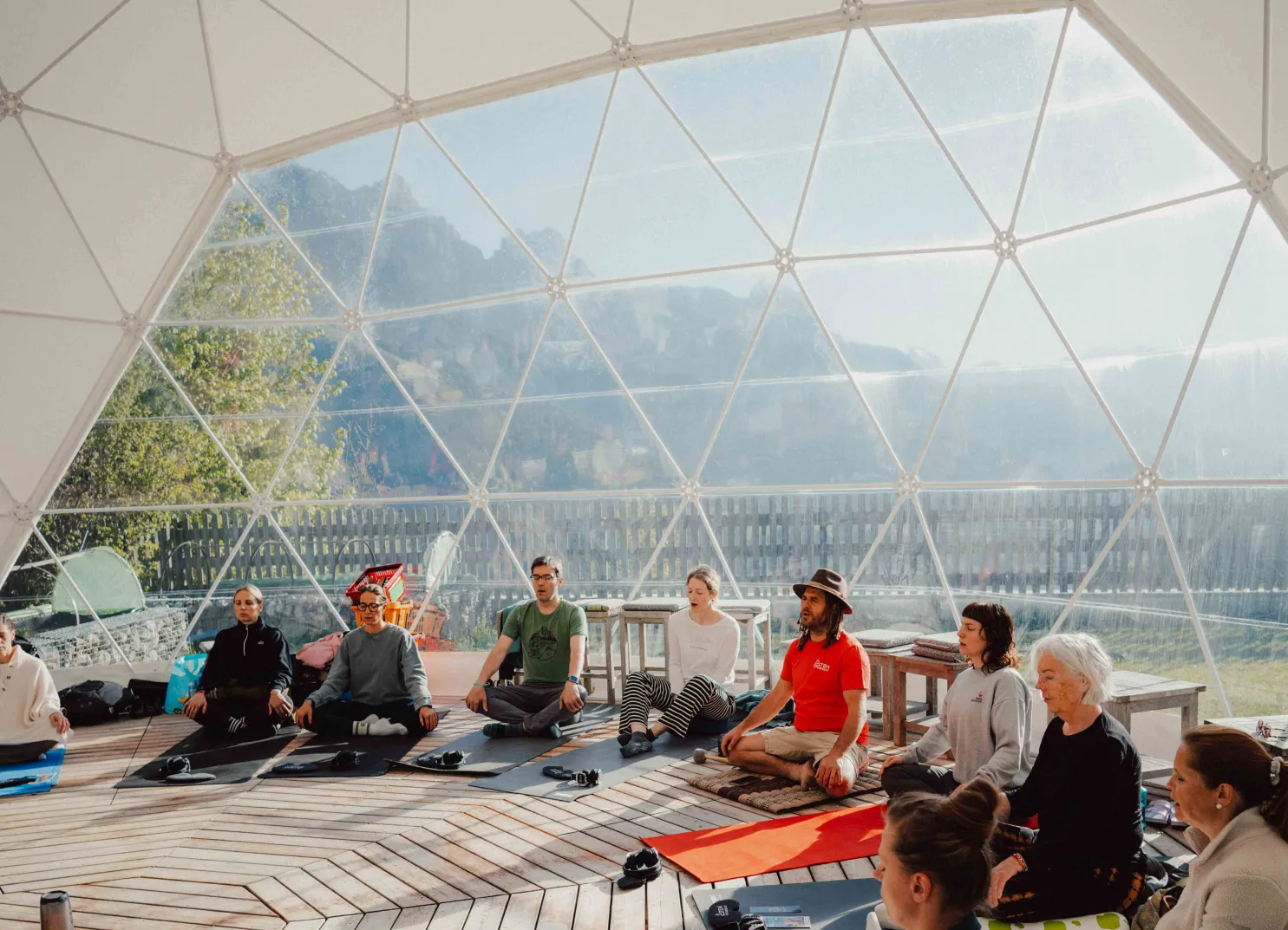 Yoga-Sitzung in einem geodätischen Dome mit Blick auf die Berge