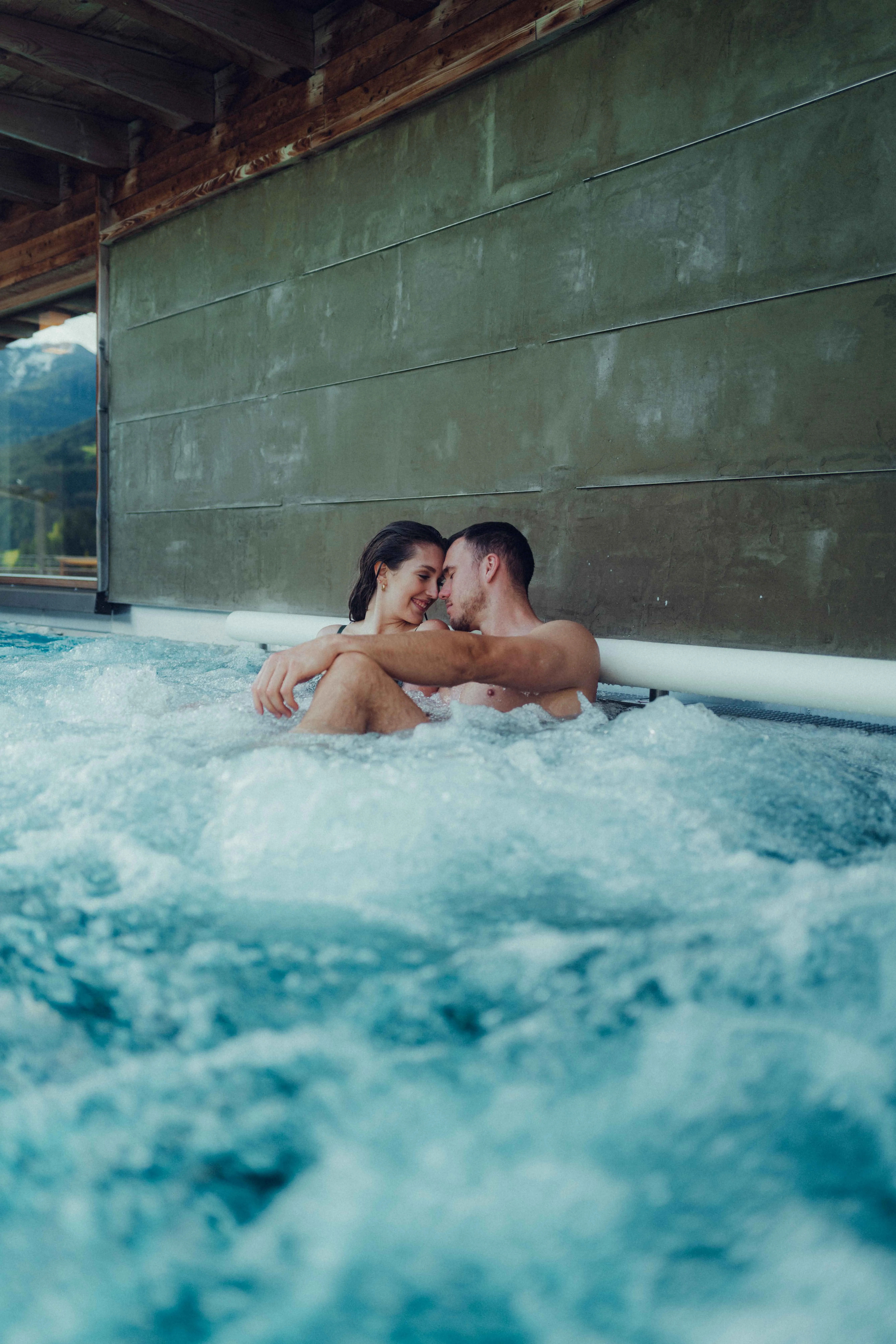 Paar entspannt im Pool mit Blasen und Hintergrundblick.