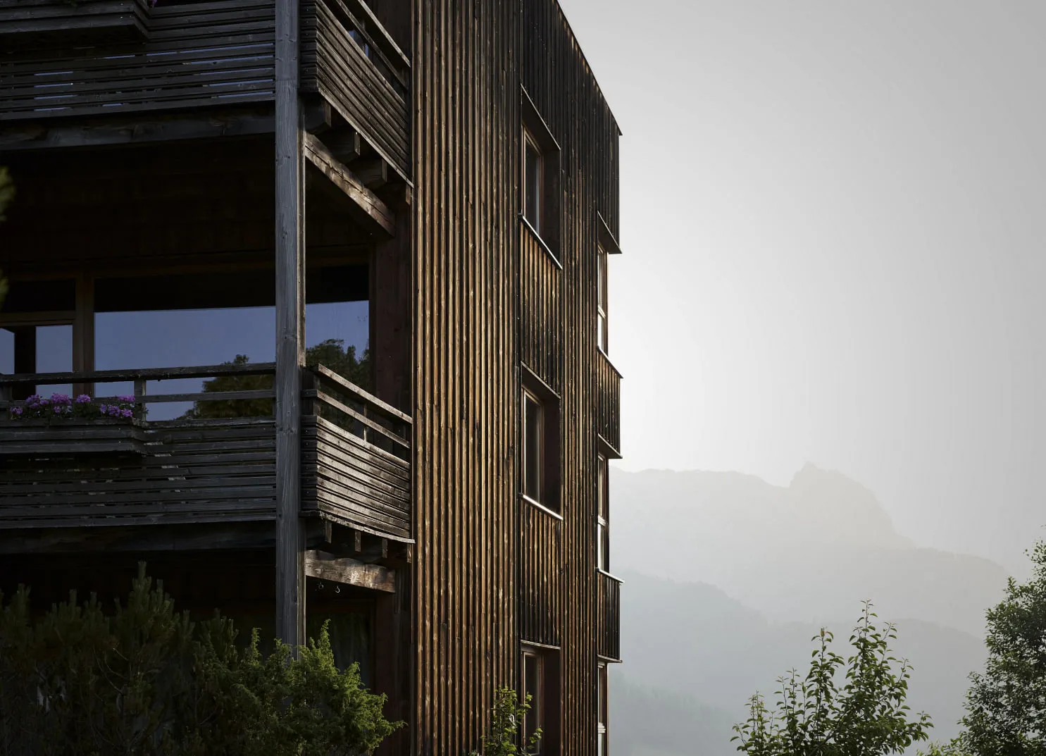 Wooden building with mountain backdrop and greenery